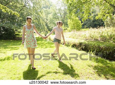 Girls walking together by river View Large Photo Image Stock Image - Girls walking together by river. Fotosearch