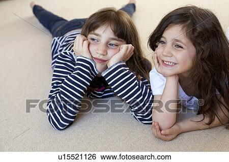 Stock Photograph - Girls watching television on carpet . Fotosearch