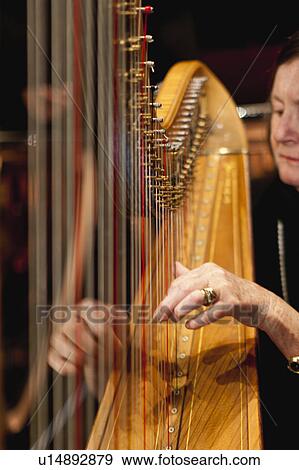 Stock Photo - Harp player in orchestra. Fotosearch