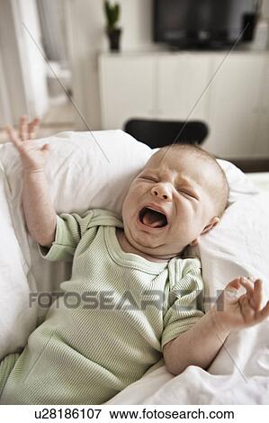 Infant crying in bed View Large Photo Image Stock Photo - Infant crying in bed. Fotosearch