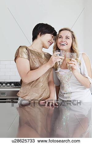 Laughing women toasting each other View Large Photo Image Stock Image - Laughing women toasting each other. Fotosearch