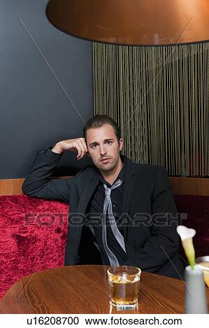 Stock Image - Man having drink in bar. Fotosearch