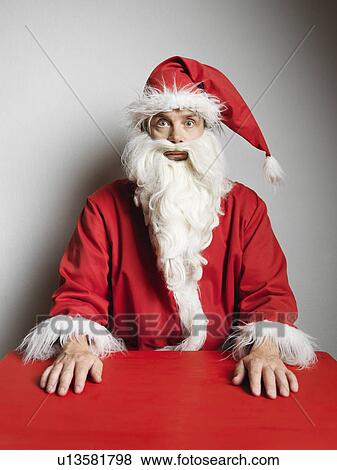 Stock Photo - Man in Santa Claus suit sitting at table. Fotosearch