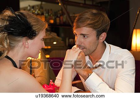 Man kissing girlfriend in restaurant View Large Photo Image Stock Image - Man kissing girlfriend in restaurant. Fotosearch