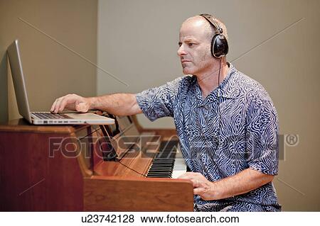 Man playing music with piano and laptop View Large Photo Image Stock Photo - Man playing music with piano and laptop. Fotosearch