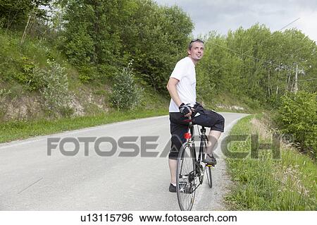 Man riding bicycle on dirt road View Large Photo Image Stock Photograph - Man riding bicycle on dirt road. Fotosearch