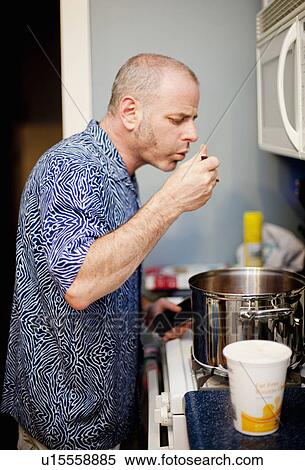 Man tasting food and cooking View Large Photo Image Stock Photography - Man tasting food and cooking. Fotosearch