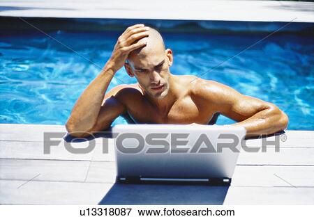 Man using laptop in swimming pool View Large Photo Image Stock Photo - Man using laptop in swimming pool. Fotosearch