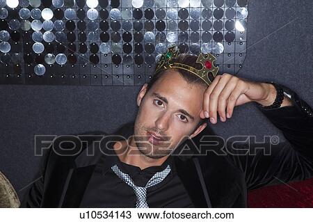 Man wearing plastic crown in bar View Large Photo Image Stock Image - Man wearing plastic crown in bar. Fotosearch