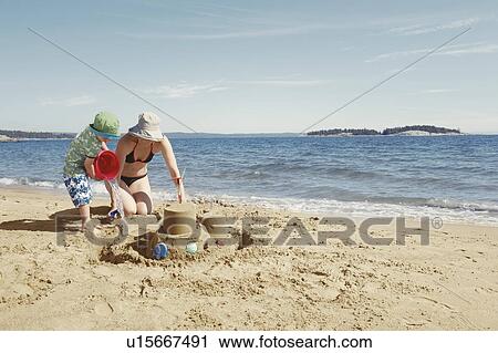 Mother and child building sandcastle View Large Photo Image Stock Image - Mother and child building sandcastle. Fotosearch