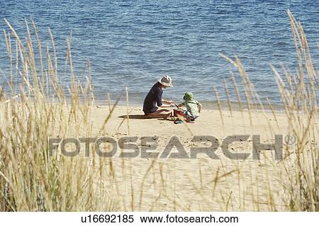 Stock Photography - Mother and child playing on beach. Fotosearch