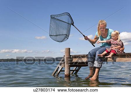 Mother and daughter fishing with net View Large Photo Image Picture - Mother and daughter fishing with net. Fotosearch