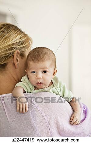 Mother cradling infant on shoulder View Large Photo Image Stock Photo - Mother cradling infant on shoulder. Fotosearch
