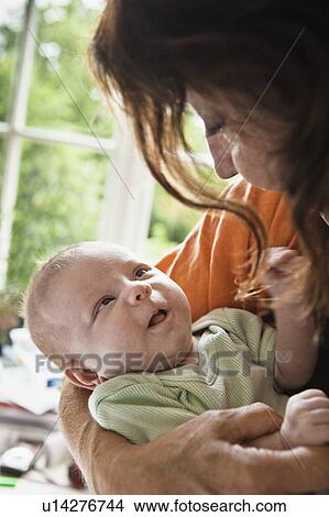 Picture - Mother cradling infant. Fotosearch