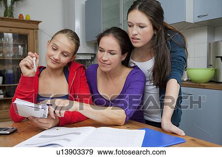 Mother helping daughter with homework View Large Photo Image Stock Photo - Mother helping daughter with homework. Fotosearch