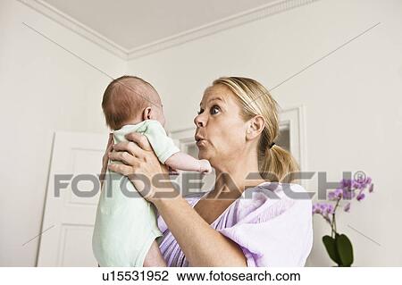 Mother holding infant in bedroom View Large Photo Image Stock Image - Mother holding infant in bedroom. Fotosearch