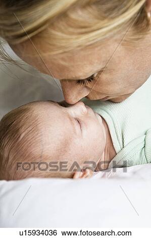 Mother touching noses with infant View Large Photo Image Stock Photograph - Mother touching noses with infant. Fotosearch