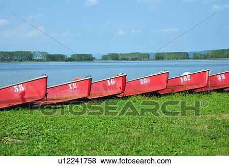 Stock Photo - Numbered boats docked by lake. Fotosearch