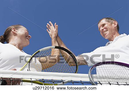 Older couple high fiving during tennis View Large Photo Image Stock Photograph - Older couple high fiving during tennis. Fotosearch