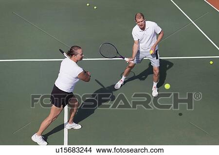 Picture - Older couple playing tennis on court. Fotosearch