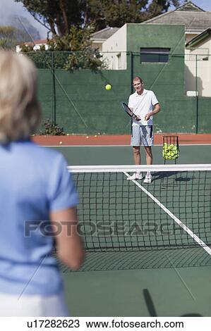 Older couple playing tennis on court View Large Photo Image Stock Image - Older couple playing tennis on court. Fotosearch