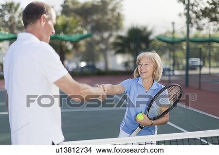 Picture - Older couple shaking hands on court. Fotosearch