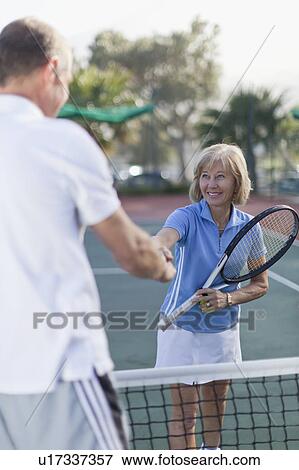 Stock Photo - Older couple shaking hands on court. Fotosearch