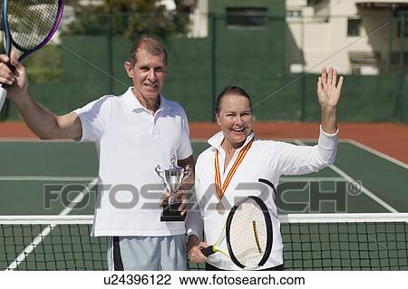 Older couple with trophy on tennis court View Large Photo Image Stock Image - Older couple with trophy on tennis court. Fotosearch