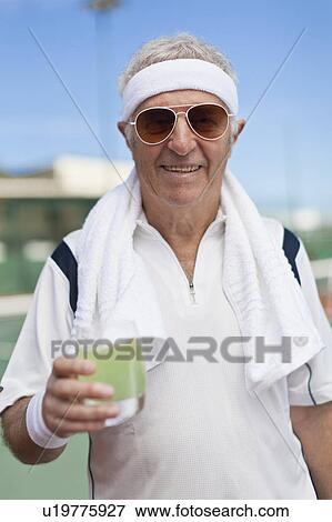 Stock Photo - Older man drinking lemonade outdoors. Fotosearch