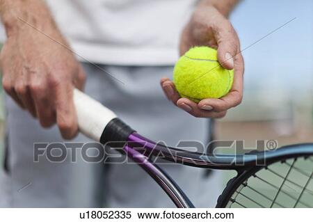 Stock Photography - Older man holding tennis ball and racket. Fotosearch