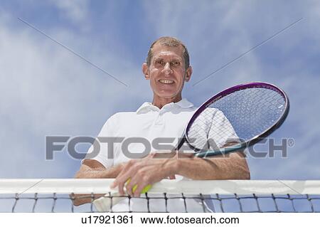 Older man leaning on tennis net View Large Photo Image Stock Image - Older man leaning on tennis net. Fotosearch