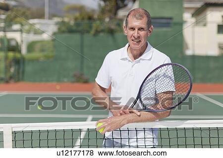 Older man standing on tennis court View Large Photo Image Stock Photo - Older man standing on tennis court. Fotosearch