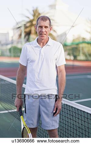 Stock Photograph - Older man with tennis racket on court. Fotosearch