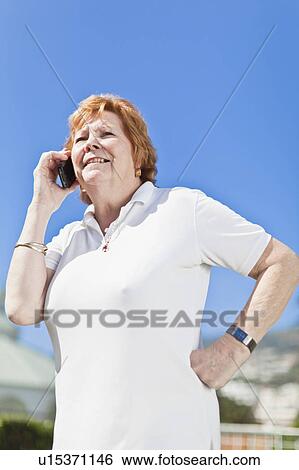 Stock Photograph - Older woman talking on cell phone. Fotosearch