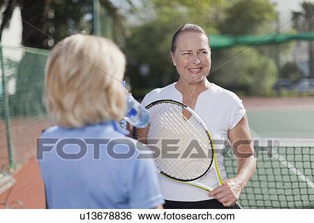 Older women talking on tennis court View Large Photo Image Stock Photograph - Older women talking on tennis court. Fotosearch