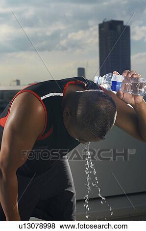 Runner pouring water on his head View Large Photo Image Stock Photo - Runner pouring water on his head. Fotosearch