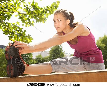 Runner stretching in park View Large Photo Image Stock Photo - Runner stretching in park. Fotosearch