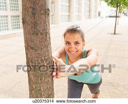 Runner stretching on city street View Large Photo Image Picture - Runner stretching on city street. Fotosearch
