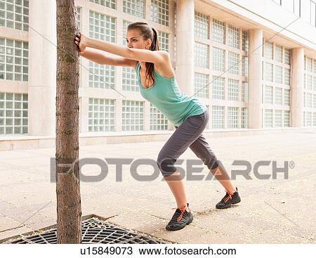 Runner stretching on city street View Large Photo Image Stock Image - Runner stretching on city street. Fotosearch