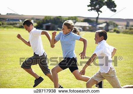 Smiling children racing in field View Large Photo Image Stock Photo - Smiling children racing in field. Fotosearch