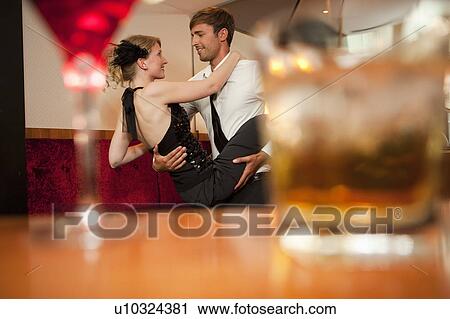 Stock Image - Smiling couple dancing in bar. Fotosearch