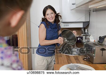 Smiling girl draining water from pot View Large Photo Image Stock Photography - Smiling girl draining water from pot. Fotosearch
