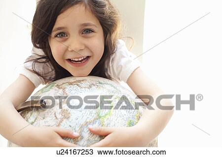 Smiling girl hugging globe indoors View Large Photo Image Stock Image - Smiling girl hugging globe indoors. Fotosearch