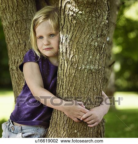 Smiling girl hugging tree View Large Photo Image Stock Image - Smiling girl hugging tree. Fotosearch