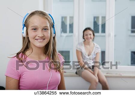 Smiling girl listening to headphones View Large Photo Image Stock Photography - Smiling girl listening to headphones. Fotosearch