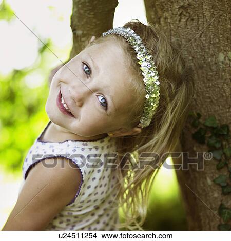 Smiling girl playing in tree View Large Photo Image Picture - Smiling girl playing in tree. Fotosearch