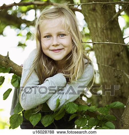 Smiling girl playing in tree View Large Photo Image Stock Photo - Smiling girl playing in tree. Fotosearch