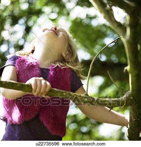 Smiling girl playing in tree View Large Photo Image Stock Photograph - Smiling girl playing in tree. Fotosearch
