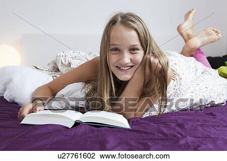 Smiling girl reading in bed View Large Photo Image Stock Image - Smiling girl reading in bed. Fotosearch
