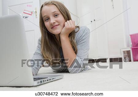 Smiling girl using laptop on floor View Large Photo Image Stock Image - Smiling girl using laptop on floor. Fotosearch